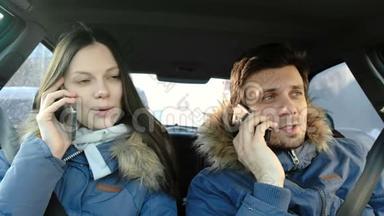 男人和女人说着手机坐在车里。<strong>正视</strong>图。